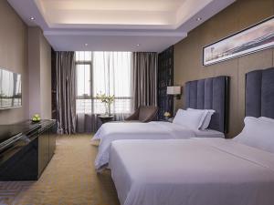 מיטה או מיטות בחדר ב-Vienna Hotel Dongguan Gaobu