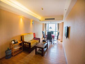 una sala de estar con un sofá y una mesa en Vienna International Hotel Luogang Wanda Plaza, en Guangzhou