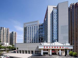 a building in a city with tall buildings at Vienna International Hotel Changsha Shumuling Subway Station in Changsha