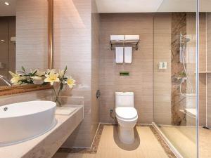 a bathroom with a toilet and a sink and a shower at Vienna International Hotel Huazhou East Beijing Road in Dongshan