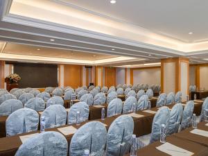 a conference room with chairs and a screen and a podium at Vienna Hotel Nanning Gaoxin District in Nanning