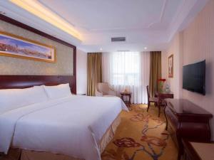 a hotel room with a large bed and a television at Vienna Hotel Guangzhou Shiling in Huadu