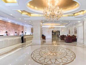 a man standing in a lobby with a chandelier at Vienna Hotel Guangzhou Yuexiu West Huifu Road in Guangzhou