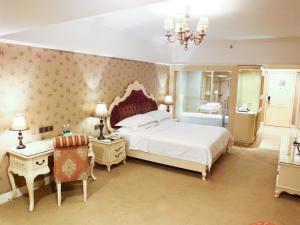 a bedroom with a large bed and a bathroom at Vienna Hotel Yongzhou Zhiyuan New Bund in Yongzhou