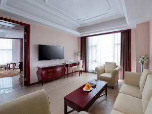 Xinyi的住宿－維也納國際酒店茂名信宜新尚路店，带沙发、桌子和电视的客厅