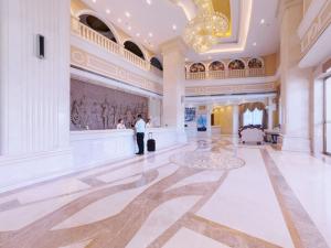 un homme debout dans une grande pièce avec hall dans l'établissement Vienna Hotel Guilin Lingchuan Shunxiang No.1 Mansion, à Guilin