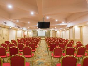 a conference room with red chairs and a screen at Vienna International Hotel Shanghai Jinqiao Industrial Park North Yanggao Road in Shanghai