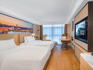 崑山市にあるVienna Hotel Kunshan North Qingyang Roadの大型ベッド1台、薄型テレビが備わるホテルルームです。