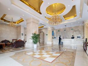 a man standing in a lobby of a hotel at Vienna Hotel Shenzhen Pingshan Shenshan Road in Longgang
