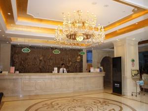 a woman standing at a counter in a hotel lobby at Vienna Hotel Xining Shengli Road in Xining