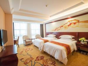 um quarto de hotel com duas camas e um grande mural em Vienna Hotel Zhejiang Huzhou Changxing Mingzhu Road em Changxing