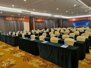une salle de conférence avec des tables et des chaises dans l'établissement Vienna Hotel Suzhou Yangcheng Lake Huayi Movie World, à Zhengyi