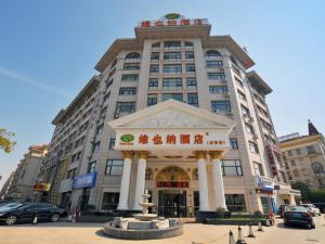 a large building with a fountain in front of it at Vienna Hotel Qidong South Gongyuan Road in Qidong