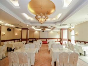 a banquet hall with white tables and white chairs at Vienna Hotel Dongguan Hou street Wanda Plaza in Dongguan