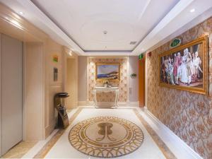 a hallway with a rug on the floor in a building at Vienna International Hotel Haikou West Bus Station in Haikou