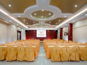 a large banquet hall with yellow tables and chairs at Vienna Hotel Huizhou Zhongxin in Huizhou