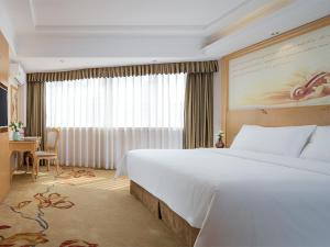 a hotel room with a large bed and a window at Vienna 3 Best Hotel Guangxi Nanning Station in Nanning +9 photos