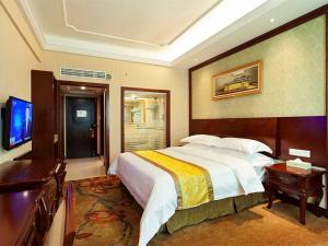 a hotel room with a large bed and a television at Vienna Hotel Nanjing Longjiang in Nanjing