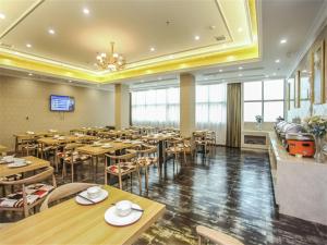 a large dining room with tables and chairs and a chandelier at Vienna Hotel Fuzhou Linchuan Avenue in Fuzhou