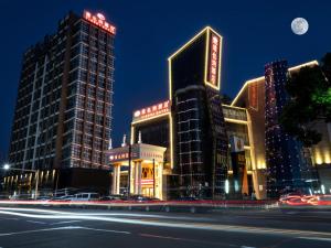 a city with tall buildings and a street at night at Vienna Hotel Shanghai Songjiang Wanda in Songjiang