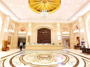 un hombre parado en un gran vestíbulo con una gran alfombra en Vienna International Hotel Guilin Wanda Plaza en Guilin