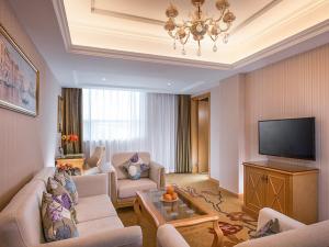 a living room with a couch and a television at Vienna Hotel Shenzhen Fuyong Subway Station in Bao'an