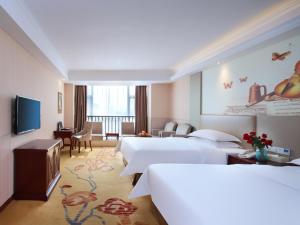 a hotel room with two beds and a television at Vienna Hotel Suzhou Mudu Changjiang No 1 in Suzhou