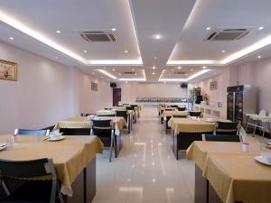una sala da pranzo con tavoli e sedie con tovaglia gialla di Vienna Hotel Shenzhen Shangjin Center a Bao'an