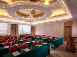 uma sala de conferências com mesas verdes e cadeiras vermelhas em Vienna Hotel Dongguan Mayong Centre Avenue em Dongguan