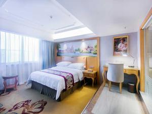 a hotel room with a bed and a desk and a bed sidx sidx at Vienna International Hotel Haikou West Bus Station in Haikou