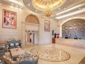 a large lobby with a chandelier and a table and chairs at Vienna International Hotel Shaoguan Fengcailou in Shaoguan
