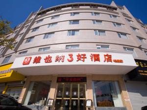 wysoki budynek z znakiem przed nim w obiekcie Vienna 3 Best Hotel Taizhou Xianju w mieście Xianju