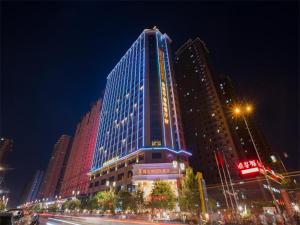 un gran edificio con luces encendidas por la noche en Vienna International Hotel Xi'an Hancheng Lake en Xi'an