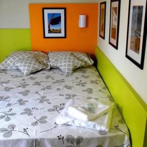 トレス・ラゴアスにあるEcobox Hotelの緑とオレンジの部屋のベッド1台