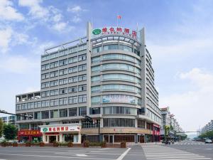 ShengzhouにあるVienna Hotel (Shengzhou Bada Hotel)の看板が立つ大きな建物