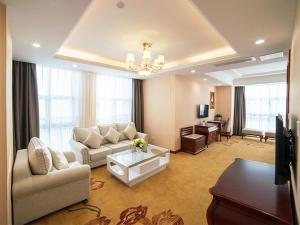 uma grande sala de estar com um sofá e uma mesa em Vienna Hotel Zhejiang Huzhou Changxing Mingzhu Road em Changxing