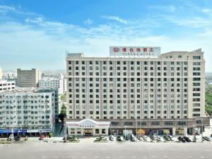een groot wit gebouw met een bord erop bij Vienna Hotel Shantou Chaoyang Mianxi Road in Shantou