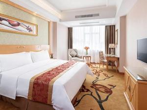 a hotel room with a large bed and a television at Vienna Hotel Tianbao Road in Bao'an
