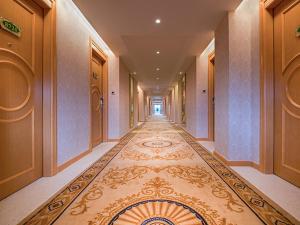 a hallway of a hotel with a rug on the floor at Vienna Hotel Shenzhen Fuyong Subway Station in Bao'an