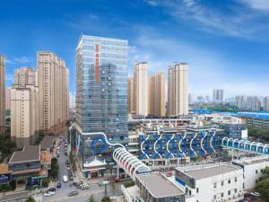 eine Stadt mit hohen Gebäuden und einem Bahnhof in der Unterkunft Vienna International Hotel Nanchang Xinjian Center in Nanchang