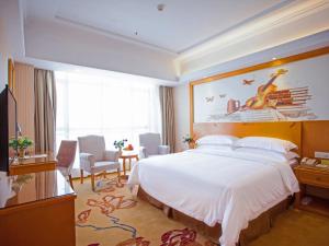 Habitación de hotel con cama grande y ventana grande. en Vienna Hotel Jiangxi Yichun City Hall, en Yichun