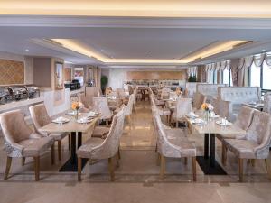 una sala da pranzo con tavoli e sedie in un ristorante di Vienna International Hotel Hengyang Chuanshan Road Branch ad Hengyang