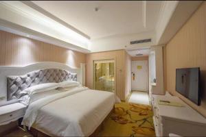 a bedroom with a large bed and a flat screen tv at Vienna International Hotel Guilin Wanda Plaza in Guilin