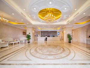 een grote kamer met een kroonluchter en een lobby bij Vienna Hotel Dongguan Shi in Dongguan