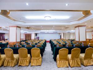 a large room with chairs and tables and a screen at Vienna International Hotel Shenzhen Songgang Wanzhao Square in Bao'an