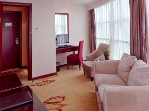 a living room with a couch and a desk at Vienna Hotel Wuxi Wangzhuang Road in Wuxi