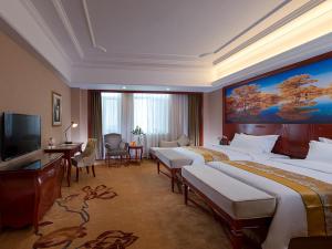 Alxa LeftにあるVienna International Hotel Inner Mongolia Alxa Leagueのベッド2台、薄型テレビが備わるホテルルームです。