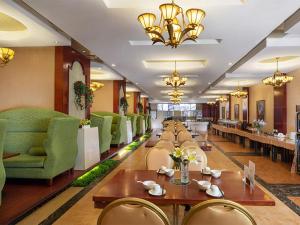 a dining room with tables and chairs in a restaurant at Vienna International Hotel Changsha Furong Plaza in Changsha