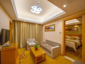 a living room with a couch and a bed at Vienna 3 Best Hotel Liuzhou Yuejiang Road in Sanjiang