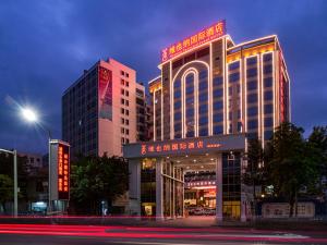 a building with a sign on top of it at Vienna International Hotel Jieyang Jieyanglou in Jieyang